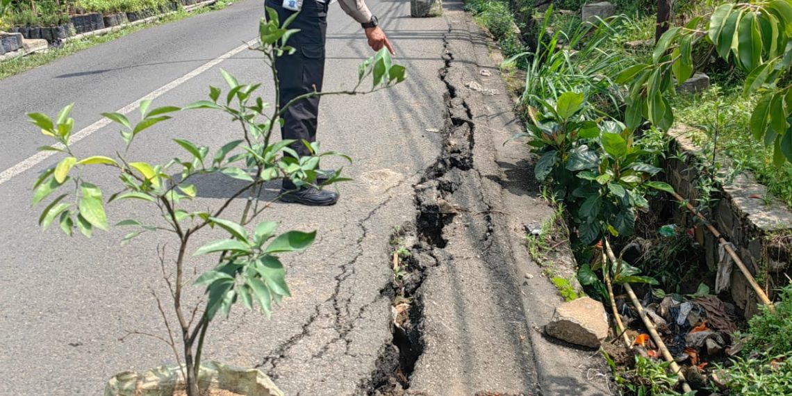 Petugas menunjuk tanah yang longsor di Jalan Sersan Bajuri Kab Bandung Barat