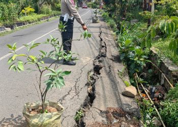 Petugas menunjuk tanah yang longsor di Jalan Sersan Bajuri Kab Bandung Barat
