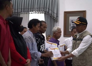 Menteri Koordinator Pembangunan Manusia dan Kebudayaan (Menko PMK) Muhadjir Effendy menyerahkan bantuan kepada warga