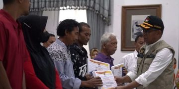 Menteri Koordinator Pembangunan Manusia dan Kebudayaan (Menko PMK) Muhadjir Effendy menyerahkan bantuan kepada warga