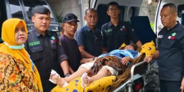 Indah Agustiyani (28), warga Dusun 1 RT02/RW02, Desa Jejalen Jaya, Kecamatan Tambun Utara korban perampasan motor di Underpass Cibitung, Jalan Bosih Raya, Kelurahan Wanasari, Kecamatan Cibitung, Kabupaten Bekasi saat dijemput dirumahnya untuk dirujuk ke RSUD Kabupaten Bekasi oleh Tim Dokter PSC 119 dan didampingi Lurah Jejalen Jaya. FOTO: ISTIMEWA