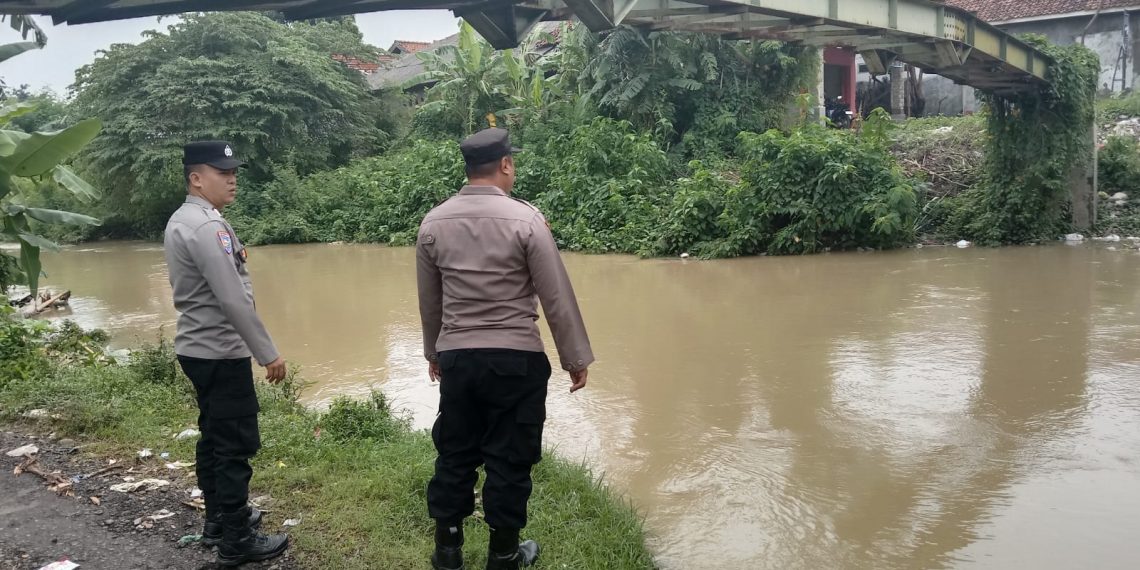 Polisi Indramayu pantau debit sungai sebagai langkah antisipasi bencana banjir yang mungkin terjadi.