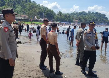 Polisi awasi kawasan wisata pantai di Cisolok Kabupaten Sukabumi yang ramai pengunjung pada Sabtu (13/4/2024).