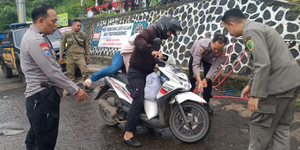 Polisi bantu warga dinginkan kanvas rem untuk mencegah terjadinya kecelakaan akibat rem blong Rabu sore (10/4/2024) di Cukang Monteng Kec. Ibun. Kabupaten Bandung.