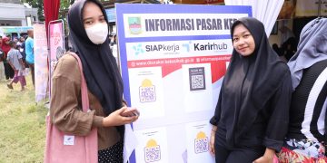 Para fresh graduate memenuhi stand pelayanan Dinas Ketenagakerjaan (Disnaker) Kabupaten Bekasi dalam program Botram Desa. Mereka antre untuk mengurus pembuatan kartu kuning dan mendapatkan informasi pasar kerja. Stand ini berlokasi di Halaman Kantor Desa Jejalen Jaya, Kecamatan Tambun Utara, pada Rabu (24/07/2024).[FOTO : ENDAR RAZIQ B / NEWSROOM DISKOMINFOSANTIK]