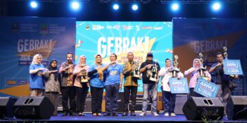 Kepala Dinas Pariwisata Kabupaten Bekasi Iyan Priyatna menyerahkan piala dan piagam penghargaan kepada para pemenang lomba fashion show perangkat daerah sekaligus secara resmi menutup Gebyar Pariwisata dan Ekonomi Kreatif (Gebrak) tahun 2024. Bertempat di Area Distrik 1 Meikarta, Cikarang Selatan. Pada Minggu, (11/08/2024) malam. FOTO : ENDAR RAZIQ B / NEWSROOM DISKOMINFOSANTIK.