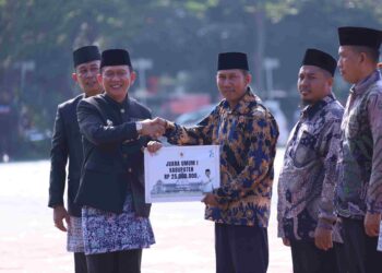 Pj Bupati Bekasi Dani Ramdan menyerahkan hadiah untuk para pemenang Lomba Kampung Bersih MakinBerani, pada Upacara Hari Jadi Kabupaten Bekasi ke-74 di Plaza Pemda Cikarang Pusat, Kamis (15/08/2024). FOTO : ENDAR RAZIQ B/NEWSROOM DISKOMINFOSANTIK.