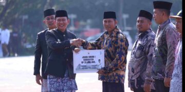 Pj Bupati Bekasi Dani Ramdan menyerahkan hadiah untuk para pemenang Lomba Kampung Bersih MakinBerani, pada Upacara Hari Jadi Kabupaten Bekasi ke-74 di Plaza Pemda Cikarang Pusat, Kamis (15/08/2024). FOTO : ENDAR RAZIQ B/NEWSROOM DISKOMINFOSANTIK.