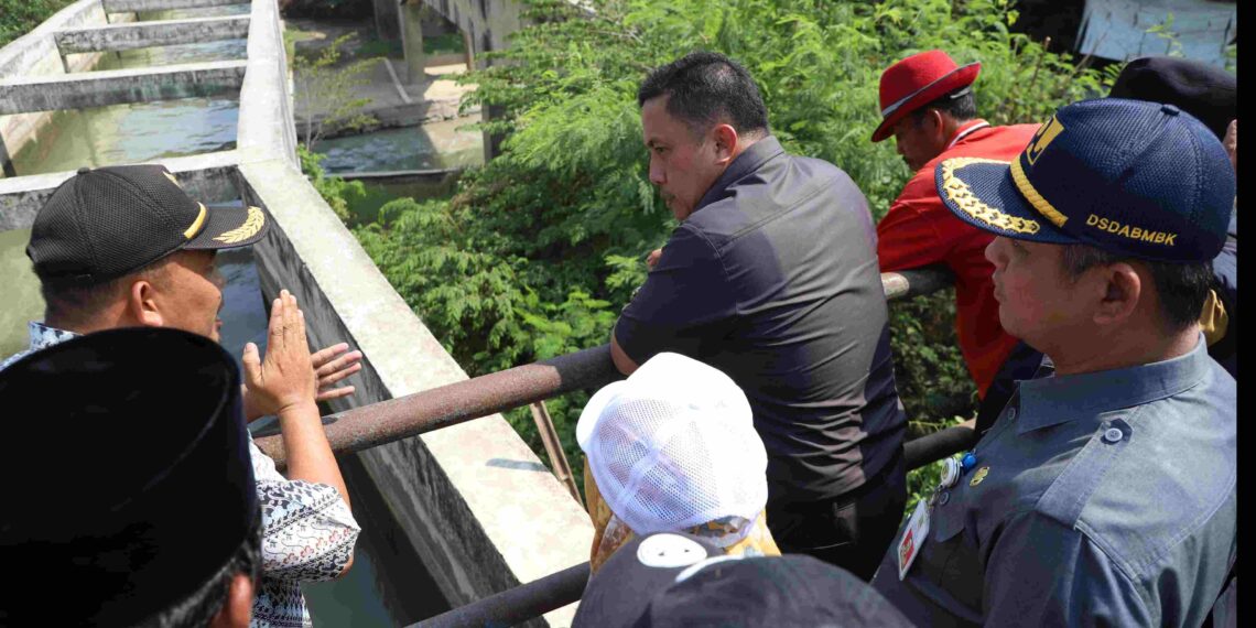 Pj Bupati Bekasi Dedy Supriyadi didampingi para kepala dinas terkait bersama camat meninjau tiga lokasi aliran sungai untuk memastikan volume dan debit air berjalan lancar, sebagai upaya mencegah lahan pertanian dan persawahan di beberapa wilayah kecamatan terhindar dari bencana kekeringan, pada Selasa (20/08/2024). FOTO : ENDAR RAZIQ B / NEWSROOM DISKOMINFOSANTIK.