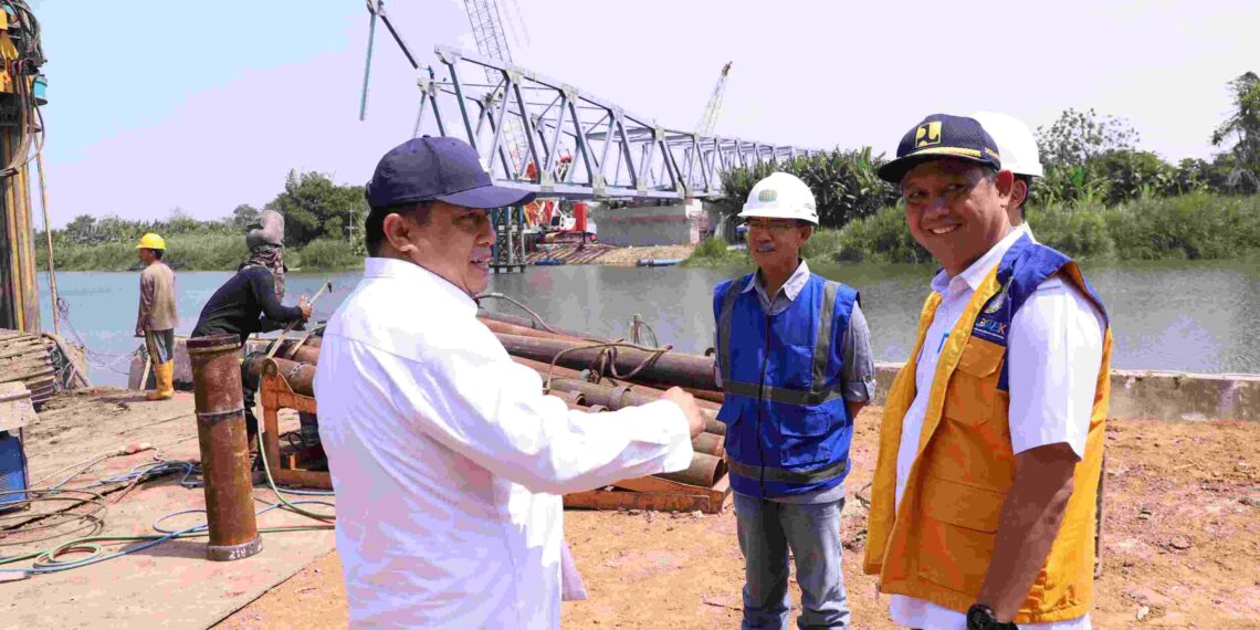 Penjabat Bupati Bekasi Dedy Supriyadi bersama Kepala Dinas (SDA-BMBK) Henri Lincoln meninjau progres pembangunan jembatan Sungai Citarum, yang menghubungkan antara Desa Pantai Mekar dengan Desa Pantai Bakti yang berada di Kecamatan Muaragembong. Pada Rabu, (09/10/2024). FOTO : ENDAR RAZIQ B / NEWSROOM DISKOMINFOSANTIK.