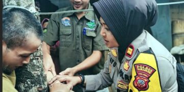 Kapolsek Lengkong, Iptu Bayu Sunarti, berusaha membujuk kakak-beradik penderita gangguan jiwa di Sukabumi mau dibawa ke rumah sakit.(Foto:Istimewa).