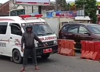 Tangkapan layar video viral, tukang ojek hadang mobil ambulans hendak terobos palang pintu KA di Kota Sukabumi.(Foto:Istimewa).