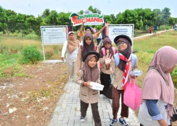 Para siswa berkembutuhan khusus melakukan kegiatan berkeliling kebun mangga Agrimania. (Dok. Satujabar.com)