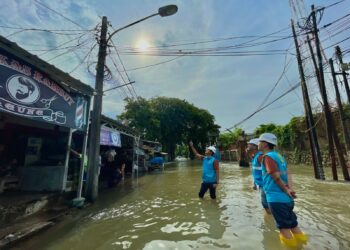 Petugas PLN memastikan jaringan listrik yang berpotensi terendam air untuk keamanan ketenagalistrikan bagi warga.