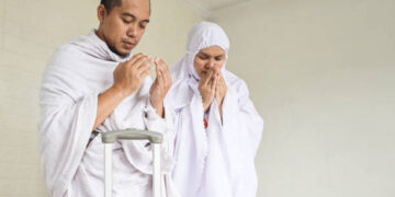 Indonesian couple praying dua before hajj and umrah, leaving home.