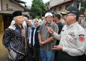 Deputi Bidang Penanganan Darurat BNPB Mayjen TNI Lukmansyah (topi hitam) bersama Wakil Ketua Majelis Permusyawarahan Rakyat (MPR) Republik Indonesia / Anggota Komisi VIII Dewan Perwakilan Rakyat (DPR) Republik Indonesia Hidayat Nur Wahid (kopiah hitam) saat meninjau dan memberikan simbolis bantuan kepada warga terdampak banjir di Kelurahan Rawajati, Kecamatan Pancoran, Jakarta Selatan, Jakarta pada Senin (3/3) sore hari. (Bidang Komunikasi Kebencanaan / Muhammad Arfari Dwiatmodjo)