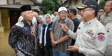 Deputi Bidang Penanganan Darurat BNPB Mayjen TNI Lukmansyah (topi hitam) bersama Wakil Ketua Majelis Permusyawarahan Rakyat (MPR) Republik Indonesia / Anggota Komisi VIII Dewan Perwakilan Rakyat (DPR) Republik Indonesia Hidayat Nur Wahid (kopiah hitam) saat meninjau dan memberikan simbolis bantuan kepada warga terdampak banjir di Kelurahan Rawajati, Kecamatan Pancoran, Jakarta Selatan, Jakarta pada Senin (3/3) sore hari. (Bidang Komunikasi Kebencanaan / Muhammad Arfari Dwiatmodjo)