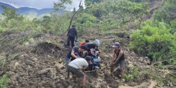Warga bergotong royong membantu pengendara melintasi jalan yang tertutup material usai peristiwa tanah longsor terjadi di Kabupaten Mamasa, Provinsi Sulawesi Barat, Selasa (13/5). (BPBD Kabupaten Mamasa via BNPB)