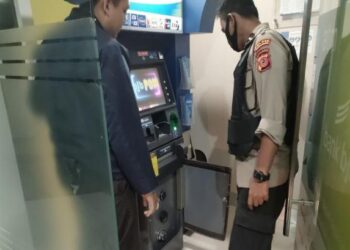 Polisi memperhatikan ATM yang rusak akibat dibobol kawanan spesialis pembobol ATM. (Dok. Istimewa)