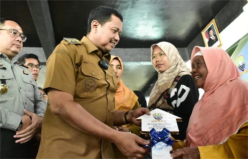 Warga Desa Mekarrahayu, Kecamatan Sumedang Selatan tersenyum bahagia ketika menerima kunci rumah baru dari Bupati Sumedang Dony Ahmad Munir, Senin (24/11/2025). (Foto: Humas Pemkab Sumedang)