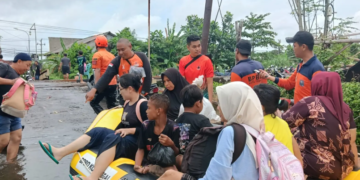 Foto : Sejumlah anggota BPBD bersama relawan mengevakuasi warga terdampak banjir menggunakan perahu karet di Kota Pekalongan, Minggu (18/1). (Foto: BNPB Via BPBD Janteng)