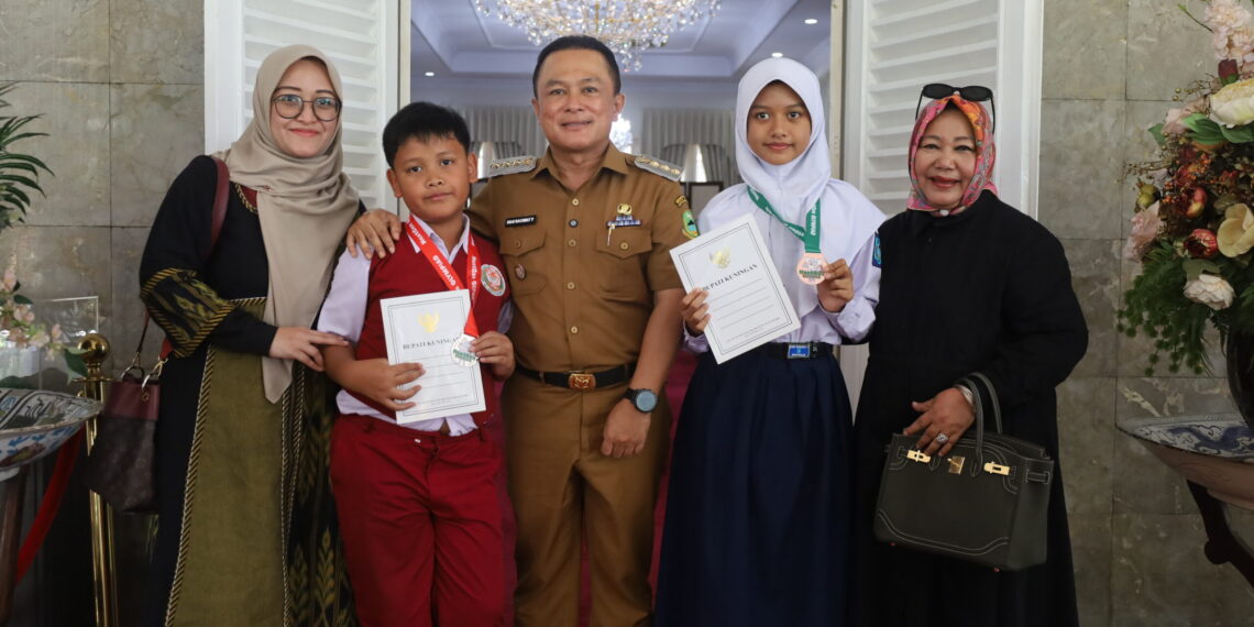 Bupati Kuningan, Dian Rachmat Yanuar (tengah) bersama dua siswa berprestasi peraih medali Olimpiade Matematika tingkat internasional, di Pendopo Bupati, Senin (20/04/2026).(Foto: Humas Pemkab Kuningan)
