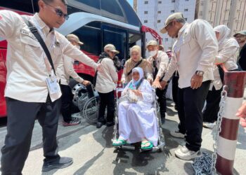 Petugas haji membantu jemaah lansia yang tiba di Makkah.(Foto: Humas Kemenhaj)