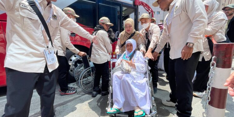 Petugas haji membantu jemaah lansia yang tiba di Makkah.(Foto: Humas Kemenhaj)