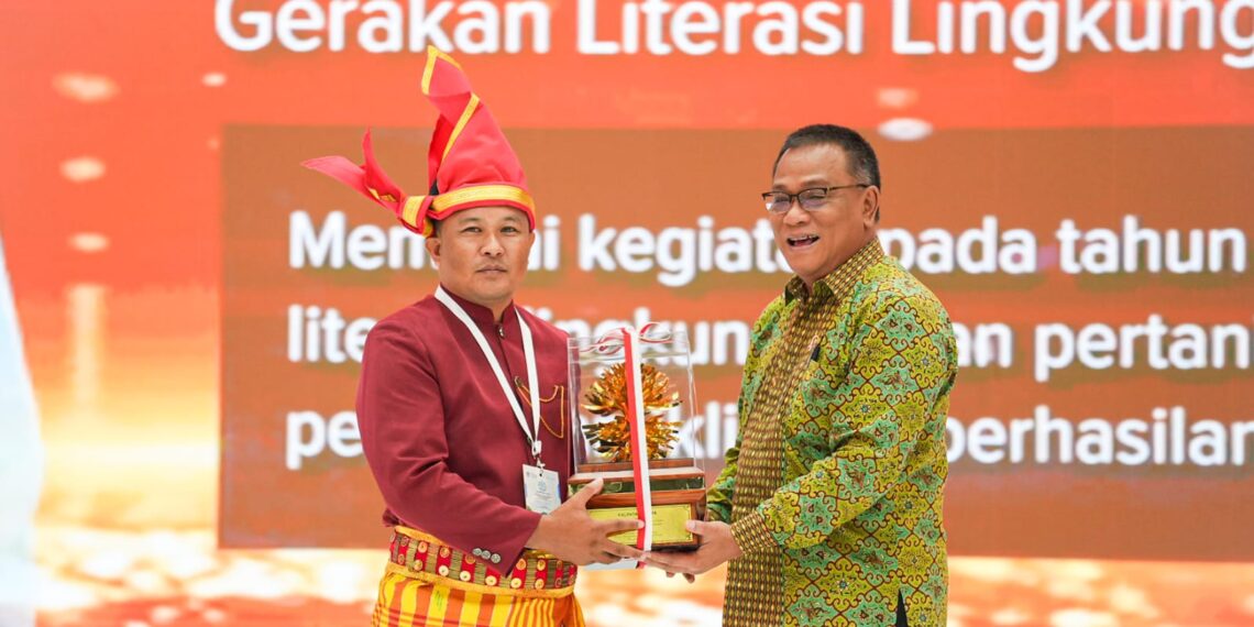 Menteri LH/Kepala BPLH, Moh Jumhur Hidayat (kanan) memberikan piala kepada salah satu penerima Kalpataru 2026.(Foto: Dok. Kementerian LH)