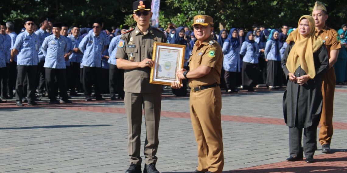 Satuan Polisi Pamong Praja (Satpol PP) Kabupaten Kuningan menerima Piagam Penghargaan Terbaik Operasi Pemberantasan Barang Kena Cukai Hasil Tembakau (BKCHT) Ilegal Tahun 2026 dari Gubernur Jawa Barat.(Foto: Humas Pemkab Kuningan)