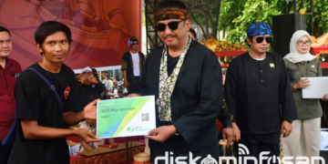 Bupati Sukabumi Asep Japar menyerahkan kartu Badan Penyelenggara Jaminan Sosial (BPJS) Ketenagakerjaan secara simbolis kepada para nelayan.(Foto: Dok. Diskominfo Kab Sukabumi)