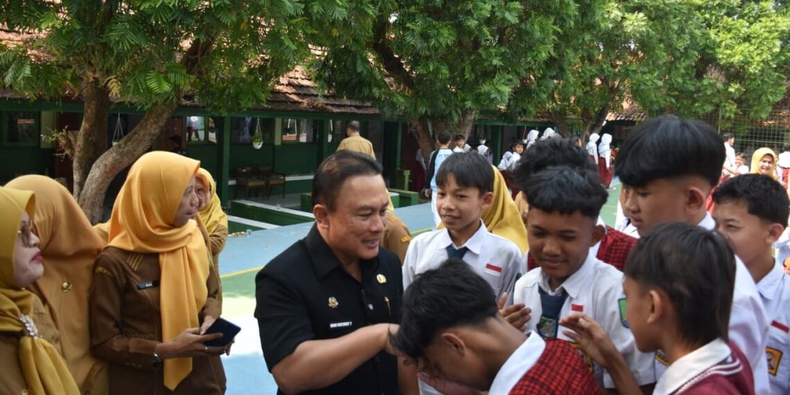 Bupati Kuningan, Dian Rachmat Yanuar menyalami siswa sekolah. Bupati menegaskan bahwa Masa Pengenalan Lingkungan Sekolah (MPLS) harus menjadi pengalaman pertama yang menyenangkan bagi seluruh peserta didik baru.(Foto: Humas Pemkab Kuningan)