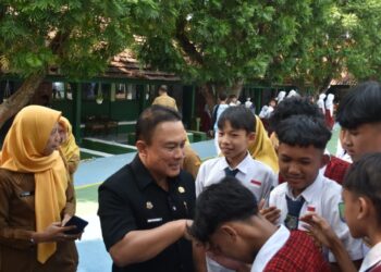 Bupati Kuningan, Dian Rachmat Yanuar menyalami siswa sekolah. Bupati menegaskan bahwa Masa Pengenalan Lingkungan Sekolah (MPLS) harus menjadi pengalaman pertama yang menyenangkan bagi seluruh peserta didik baru.(Foto: Humas Pemkab Kuningan)