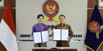 Ketua Dewan Komisioner OJK Friderica Widyasari Dewi dan Ketua KPPU M. Fanshurullah Asa.(Foto: Dok. OJK)