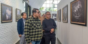 Menteri Ekonomi Kreatif/Kepala Badan Ekonomi Kreatif (Ekraf), Teuku Riefky Harsya (kiri), bersama Fotografer profesional sekaligus pendiri Huta Art Space, Edward Tigor Siahaan (kanan) mengamati foto pada pameran Toba Heritage Photo Exhibition 2026 di Huta Art Space, Sumatra Utara, Sabtu (11/7/2026).