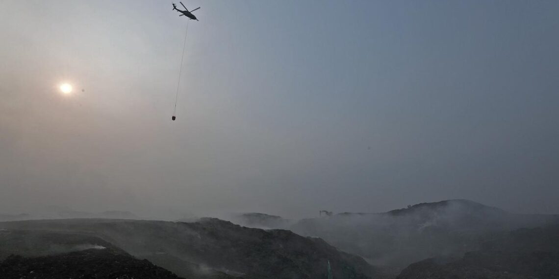 Foto : Helikopter water bombing BNPB beroperasi memadamkan kebakaran tempat pembuangan akhir (TPA) Jatiwaringin, Kecamatan Mauk, Kabupaten Tangerang, Banten, Selasa (7/6). (Bidang Komunikasi Kebebencanaan/Danung Arifin)