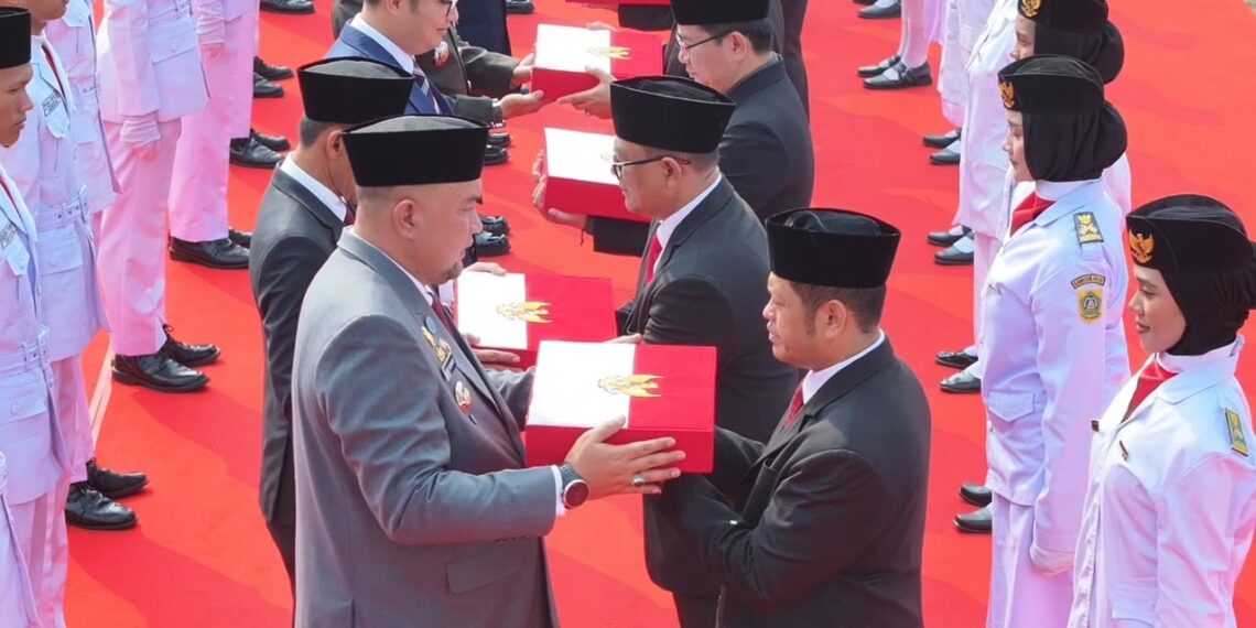 Bupati Bogor Rudy Susmanto menyerahkan Bendera Merah Putih kepada 40 kecamatan se-Kabupaten Bogor, di Alun-Alun Kabupaten Bogor, Rabu (12/8).(Foto: Humas Pemkab Bogor)