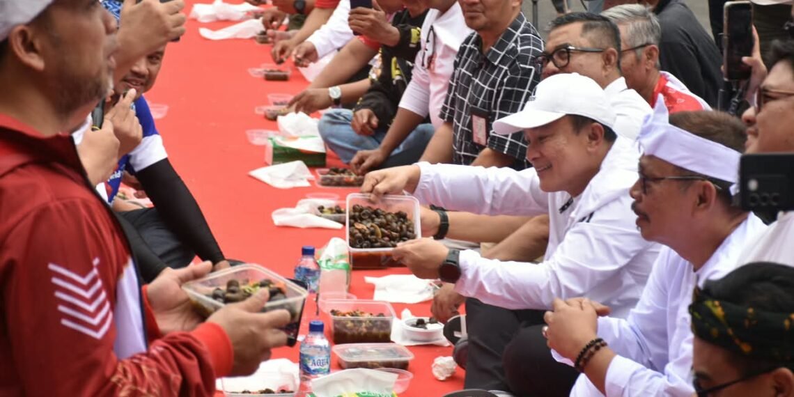 Bupati Kuningan Dian Rachmat Yanuar memperlihatkan hidangan tutut di BUMDes Festival Jawa Barat 2026.(Foto: Humas Pemkab Kuningan)