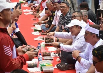 Bupati Kuningan Dian Rachmat Yanuar memperlihatkan hidangan tutut di BUMDes Festival Jawa Barat 2026.(Foto: Humas Pemkab Kuningan)
