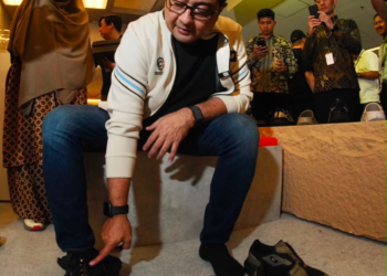 Menteri Ekonomi Kreatif/Kepala Badan Ekonomi Kreatif (Ekraf), Teuku Riefky Harsya mencoba salah satu produk sepatu di Jakarta Sneakers Day (JSD) Blok M Festival 2026, Jakarta, Jumat (31/07/2026).(Dok. Biro Komunikasi Kementerian Ekonomi Kreatif/Badan Ekonomi Kreatif)