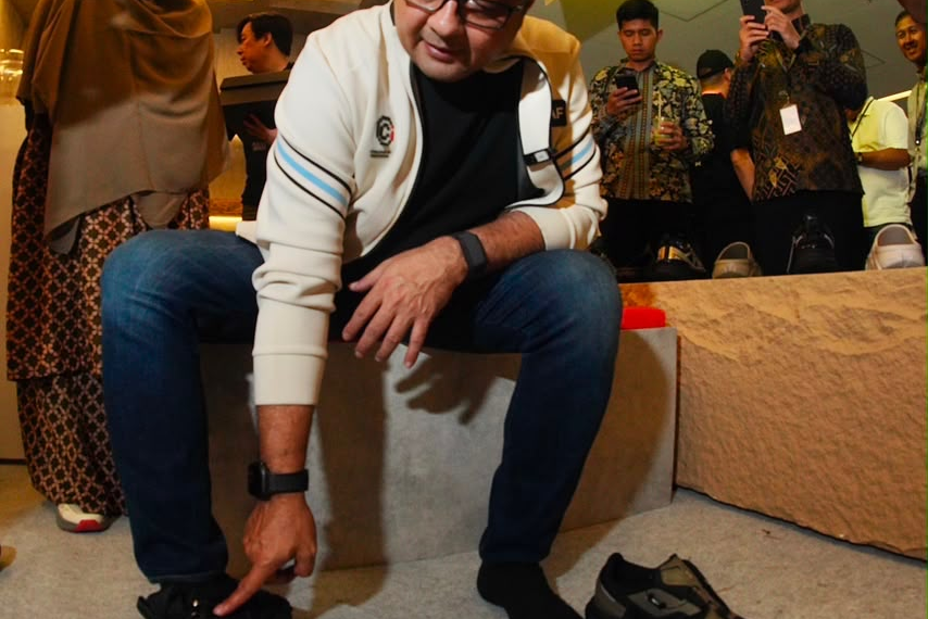 Menteri Ekonomi Kreatif/Kepala Badan Ekonomi Kreatif (Ekraf), Teuku Riefky Harsya mencoba salah satu produk sepatu di Jakarta Sneakers Day (JSD) Blok M Festival 2026, Jakarta, Jumat (31/07/2026).(Dok. Biro Komunikasi Kementerian Ekonomi Kreatif/Badan Ekonomi Kreatif)