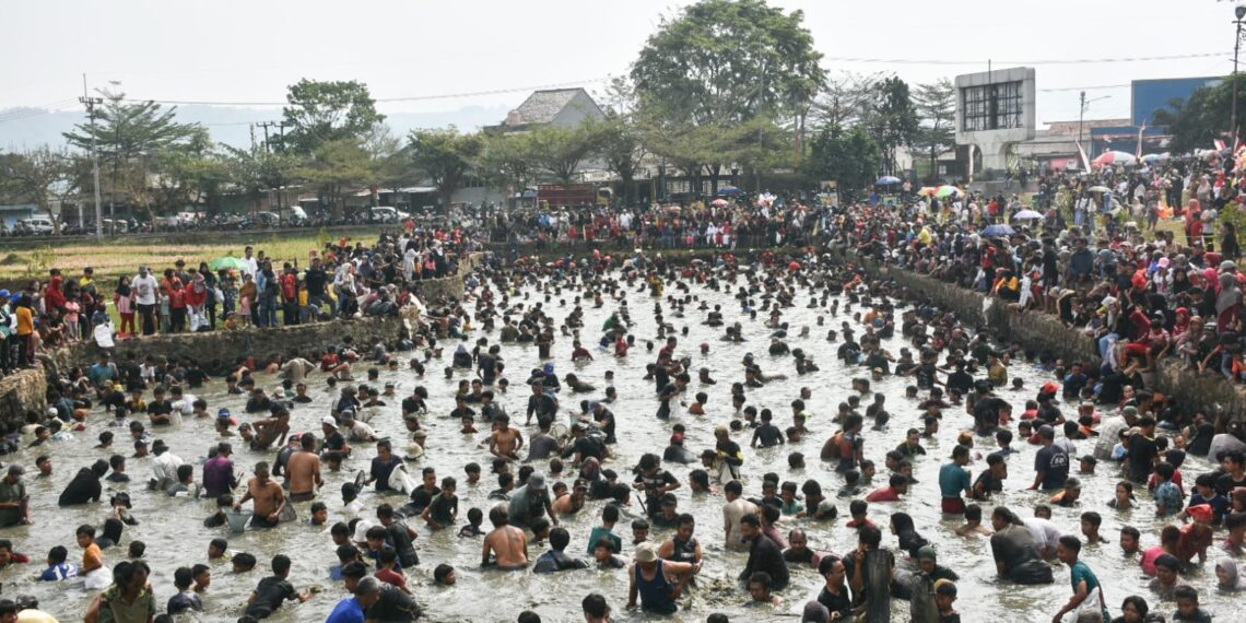 Warga tumpah ruah mengikuti tradisi ngagogo lauk di Kolam Masjid Al Kamil, Pusat Pemerintahan Sumedang (PPS), Senin (17/8/2026) memeriahkan Hari Ulang Tahun (HUT) ke-81 Kemerdekaan Republik Indonesia.(Foto: Humas Pemkab Sumedang)