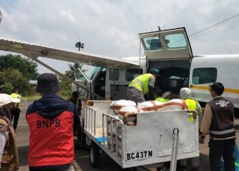 Petugas memuat bahan semai berupa Natrium Klorida ke dalam pesawat yang akan digunakan untuk operasi modifikasi cuaca guna menekan titik panas.(Foto: Tim OMC Provinsi Lampung)