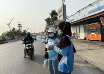 Sejumlah orang membagikan masker untuk menekan bahaya asap akibat karhutla. Berdasarkan data Kemenkes per (21/8), tujuh provinsi yang terdampak karhutla meliputi Jambi, Riau, Sumatera Selatan, Kalimantan Barat, Kalimantan Tengah, Kalimantan Selatan, dan Kalimantan Timur.(Foto: Website Kemenkes