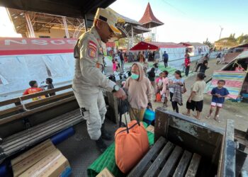 Para penyintas gempa M 7,7 Flores, yang sebelumnya tinggal sementara di pengungsian terpusat Gor Samador, Maumere, Kabupaten Sikka, Nusa Tenggara Timur, naik ke truk TNI AL untuk diantar kembali ke rumah masing-masing, Senin (24/8). (Foto: Bidang Komunikasi Kebencanaan / Danung Arifin)