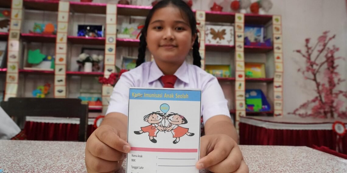 Siswa SD memegang kartu imunisasi.(Foto: Dok. Kemenkes)