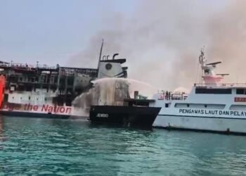 Kapal Negara (KN) Trisula P.111 melakukan proses pendidingan kebakaran KMP Batumandi di alur masuk Pelabuhan Penyeberangan Merak, Banten.(Foto: Ditjen Hubla Kemenhub)