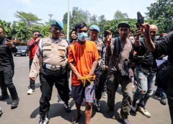 Petugas mengawal terduga pelaku pencurian kabel traffic light di Kota Bandung yang ditangkap saat tengah beraksi memotong kabel traffic light di kawasan Simpang Dago, Kota Bandung.(Foto: Humas Pemkot Bandung)