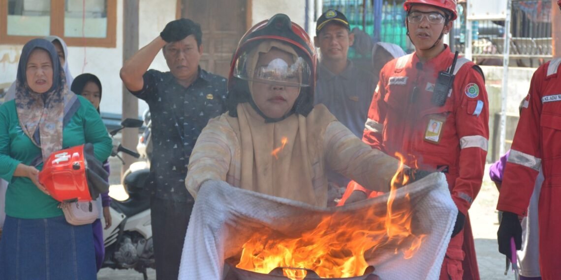 Seorang warga memadamkan api pada Sosialisasi Major Emergency Drill di Aula Balai Desa Majakerta, Kecamatan Balongan, Kabupaten Indramayu, Selasa (20/10/2026) yang digelar PT Pertamina Patra Niaga Refinery Unit Balongan.(Foto: Istimewa)